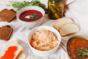 Why does eating raw fermented sauerkraut help with bloating after heavy meals?