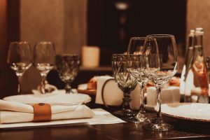What is the proper etiquette for arranging wine and water glasses on a dinner table?